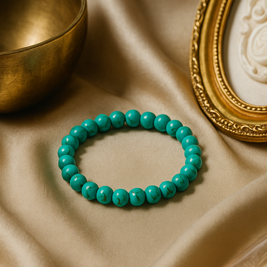 Turquoise beaded bracelet on a beige fabric background with a gold bowl and decorative frame.